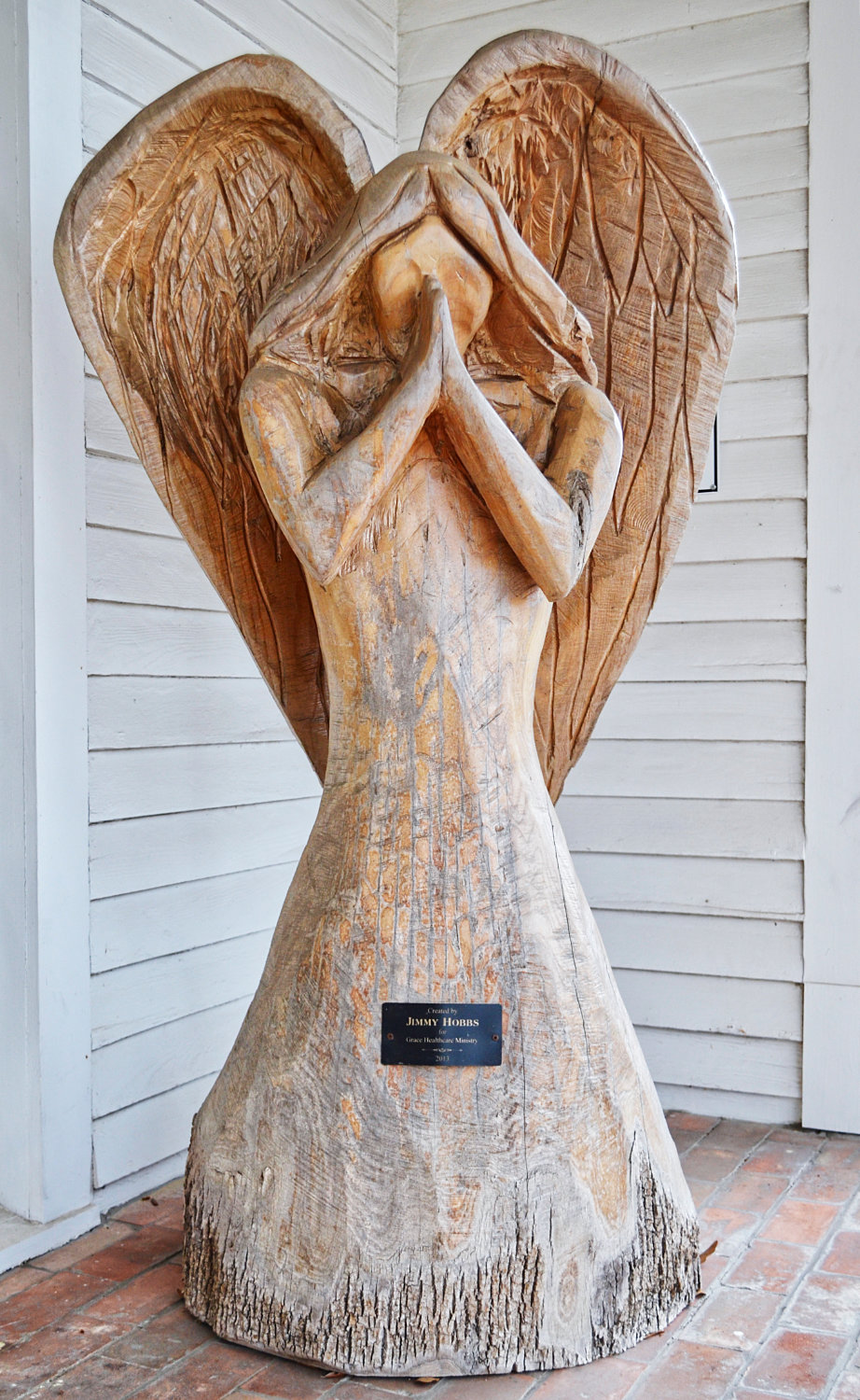 A wood carving of a praying angel adorns the front porch of the Grace Healthcare Ministry. It was created by Jimmy Hobbs in 2013.